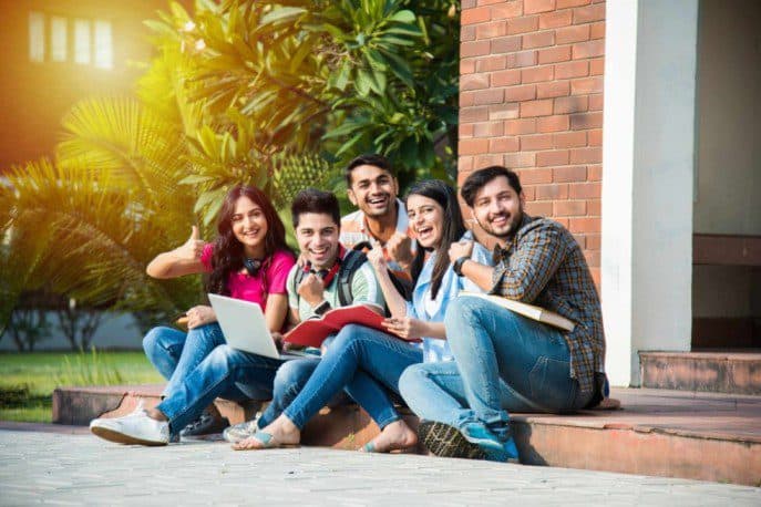 young-asian-indian-college-students-reading-books-studying-laptop-preparing-exam-working-group-project-while-sitting-grass-staircase-steps-college-campus-1-1-1-1-1